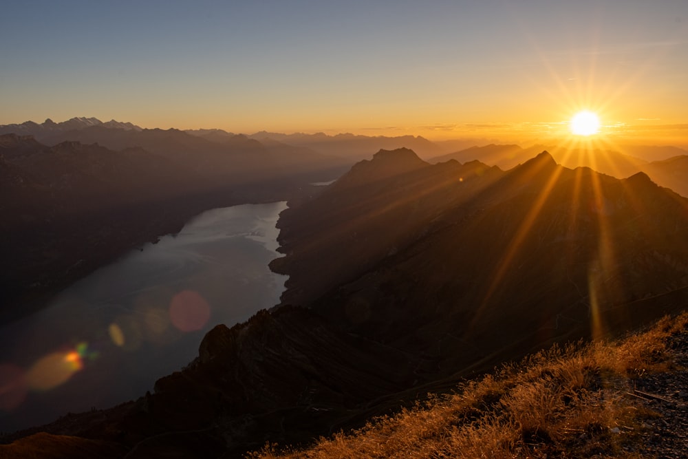 the sun is setting over a mountain range