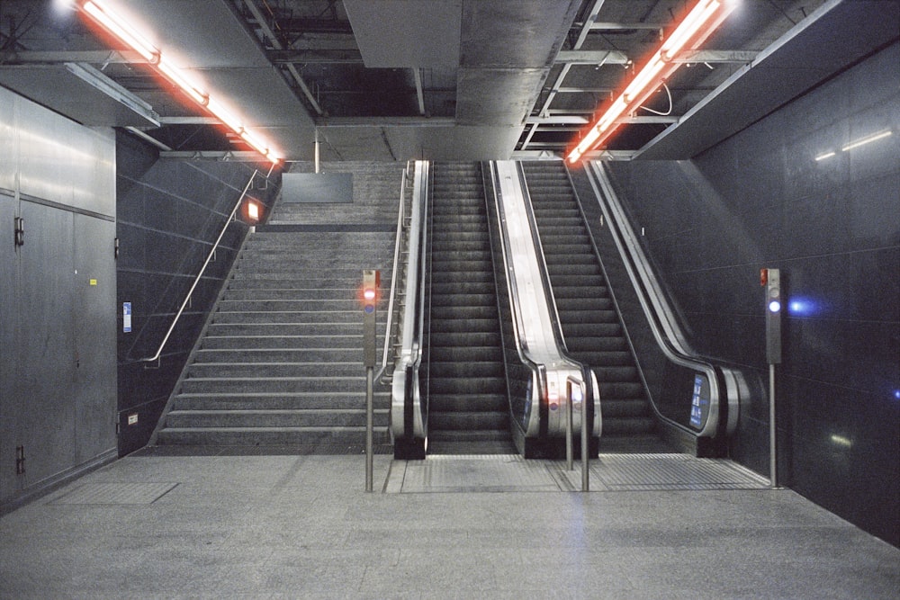 an escalator in a subway station with two escalators