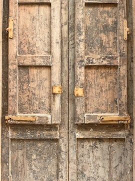 Rustic barn door with weathered wood and iron hinges.