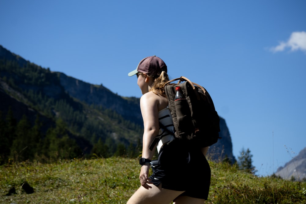 a woman with a backpack walking up a hill