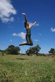 a woman jumping in the air with a frisbee