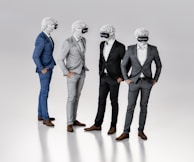 Four figures dressed in suits stand together, each wearing a virtual reality headset and featureless white masks resembling classical sculptures. They appear to be engaged in conversation or interaction, exhibiting a blend of classical and modern elements.