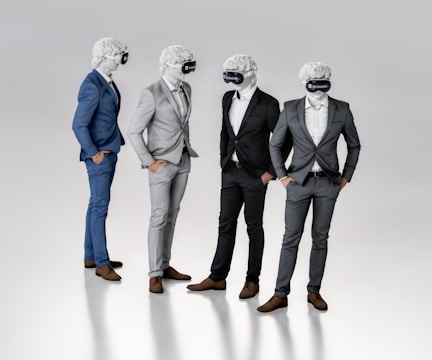 Four figures dressed in suits stand together, each wearing a virtual reality headset and featureless white masks resembling classical sculptures. They appear to be engaged in conversation or interaction, exhibiting a blend of classical and modern elements.