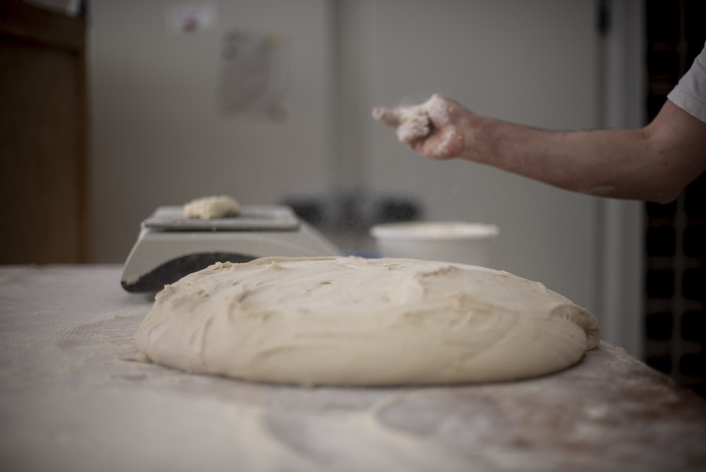 a person is kneading dough on a table