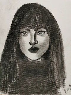Detailed charcoal portrait capturing expressive facial features and soft shadows.