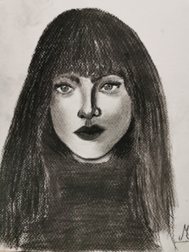 A vibrant charcoal portrait showing expressive eyes and subtle shading.