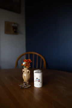 Handcrafted wooden table with ceramic vase on top, set in a cozy living space.