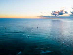A serene ocean view with fishing boats at sunrise.