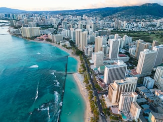 A serene aerial view of Honolulu coastline with luxury residential buildings under a clear blue sky.