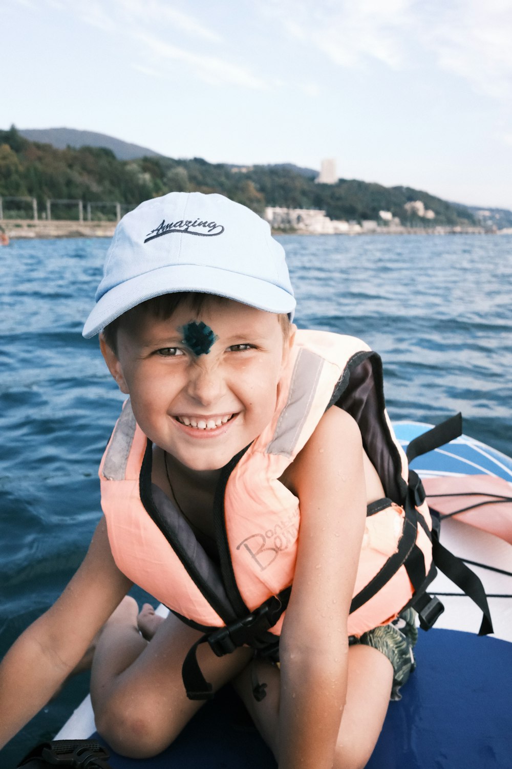 a young boy in a life jacket on a boat