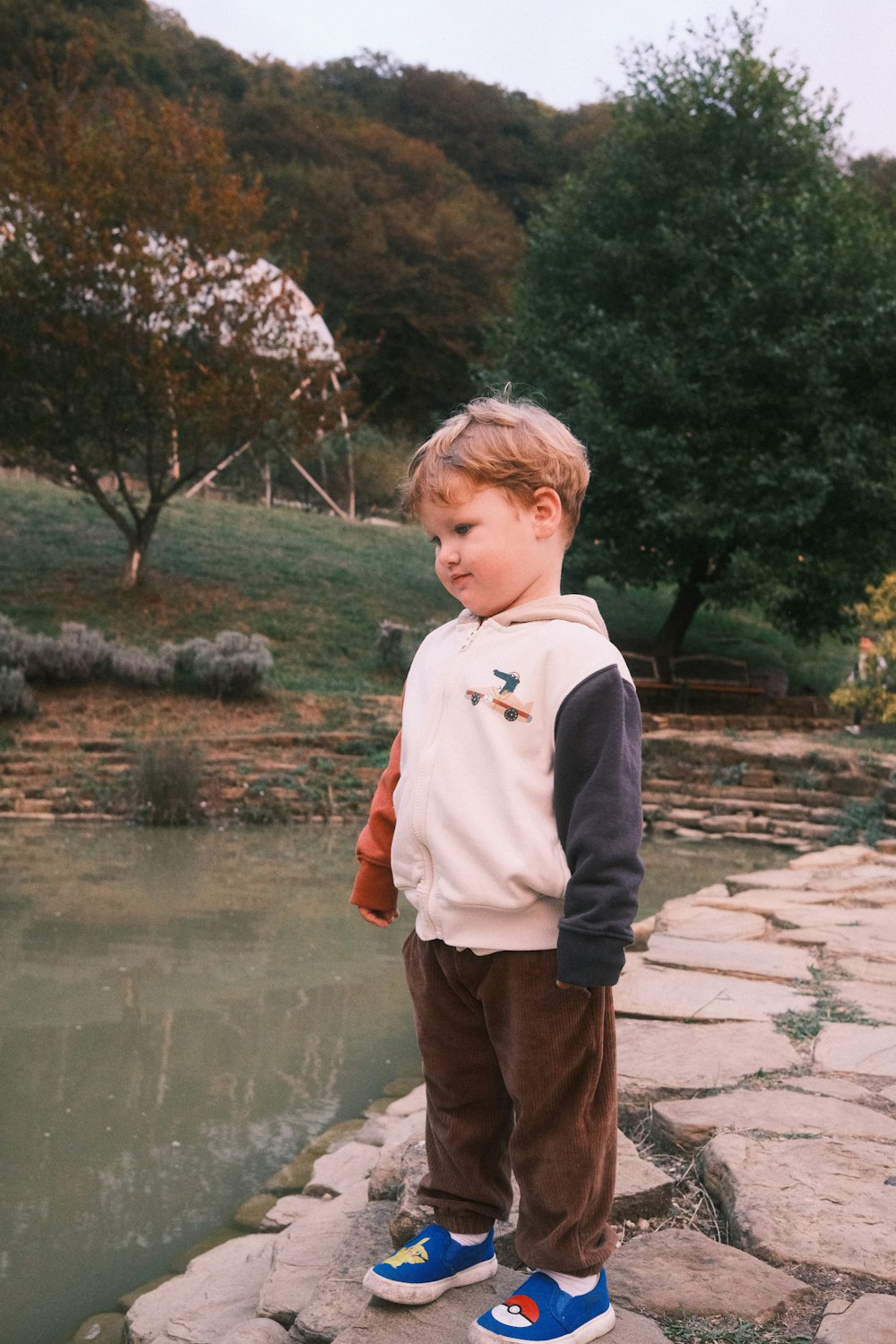 a little boy that is standing on some rocks