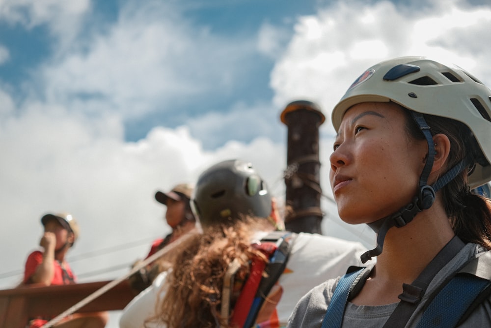 a woman wearing a helmet standing next to a man