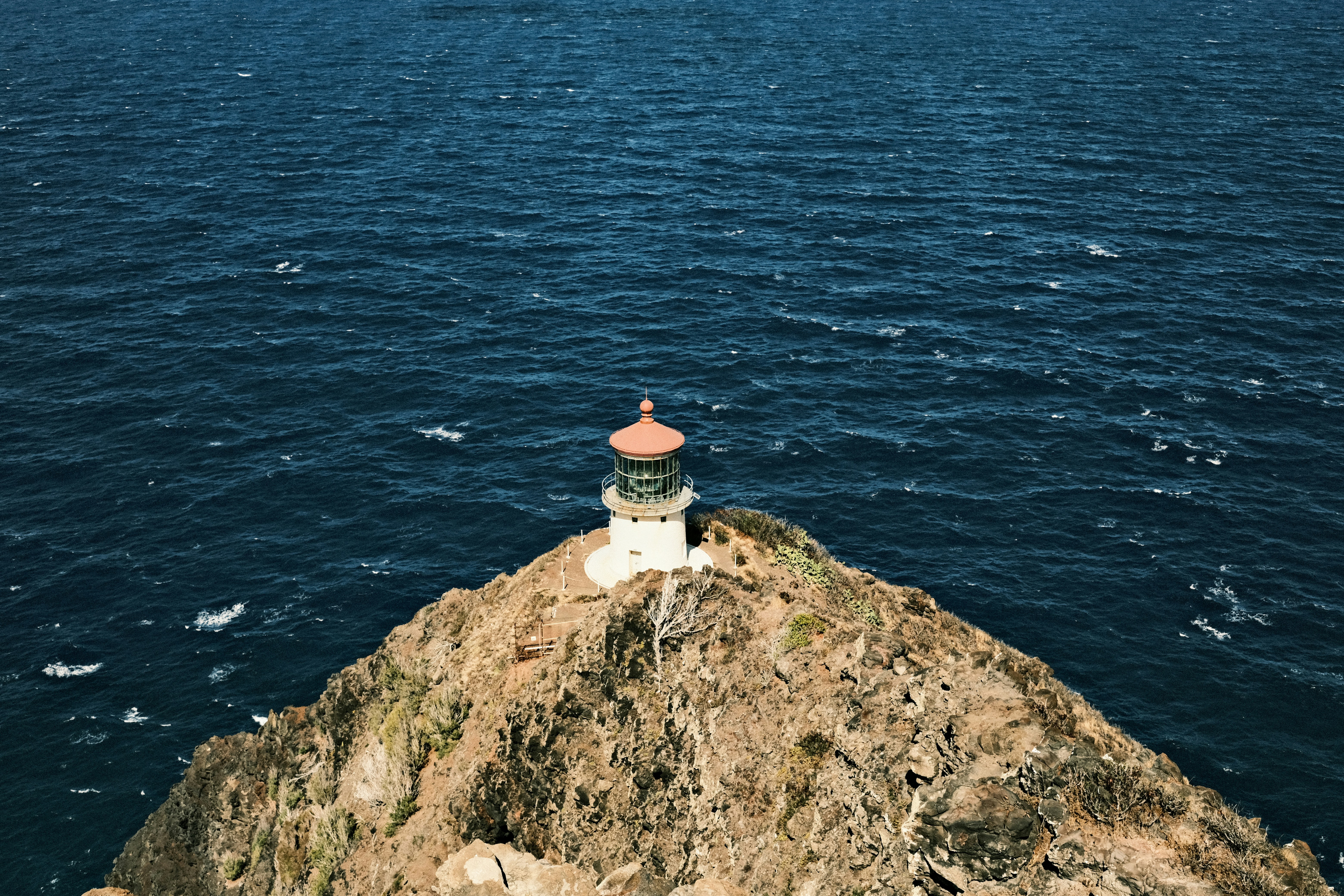 a light house on a small island in the middle of the ocean