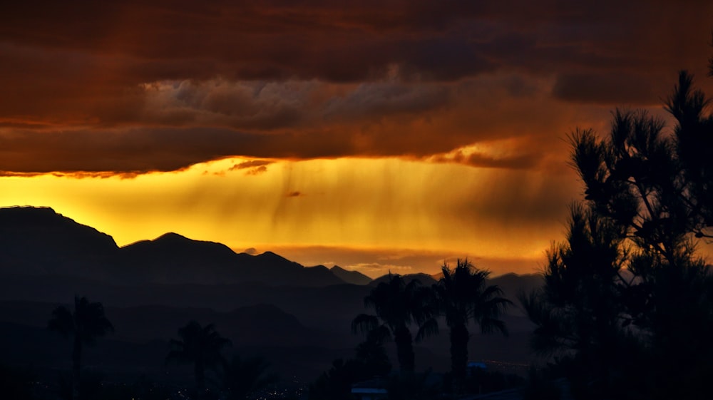 the sun is shining through the clouds over the mountains