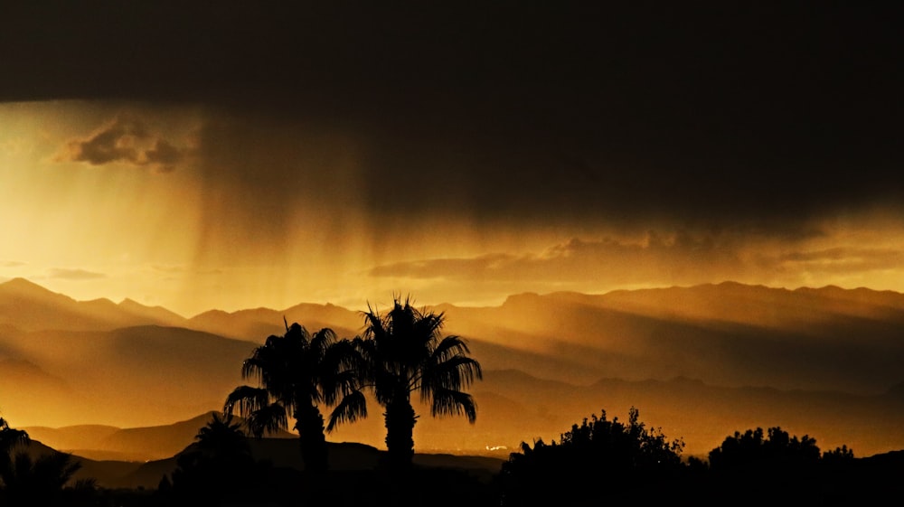 the sun is shining through the clouds over the mountains