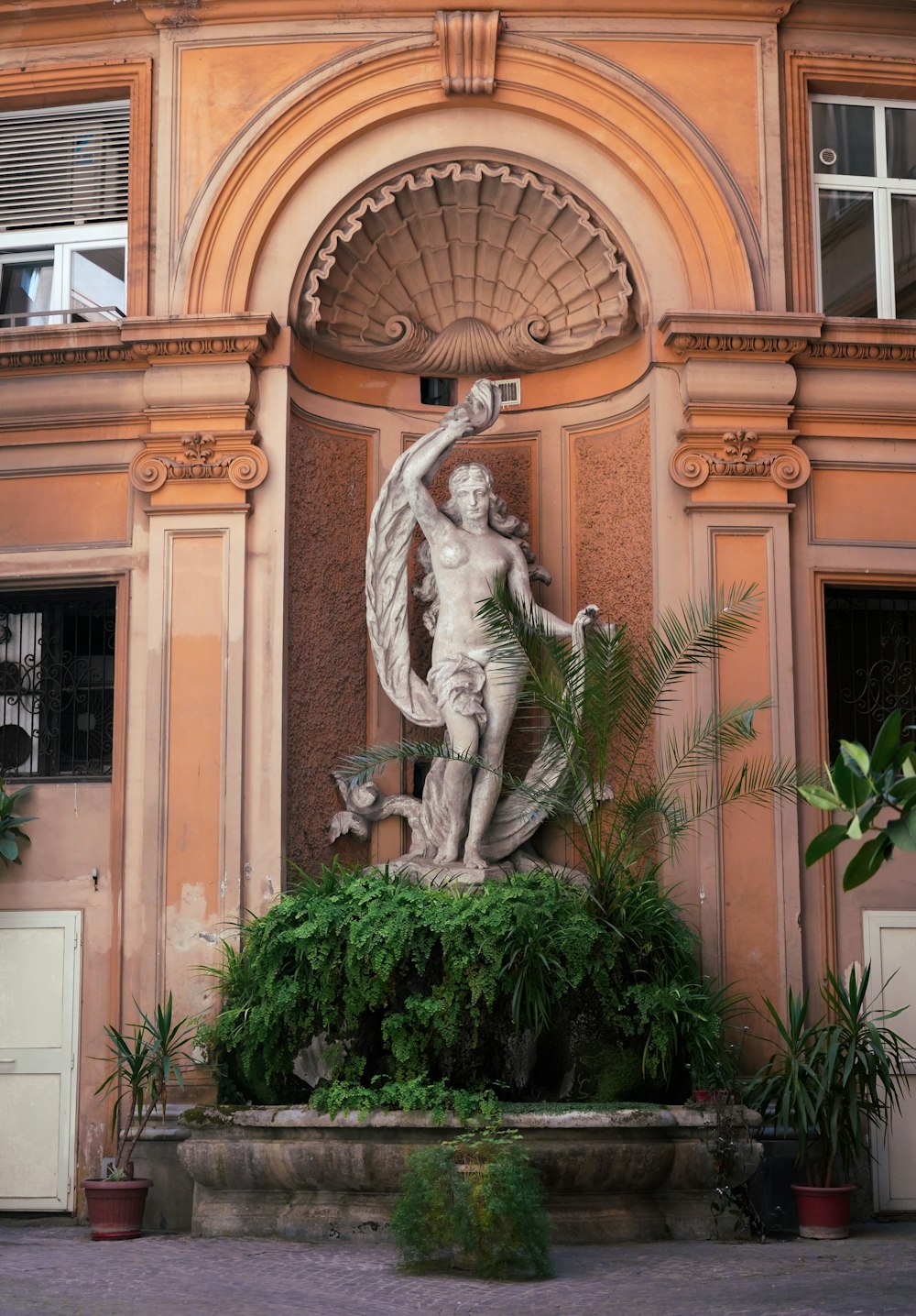 a statue of a man holding a bird in front of a building