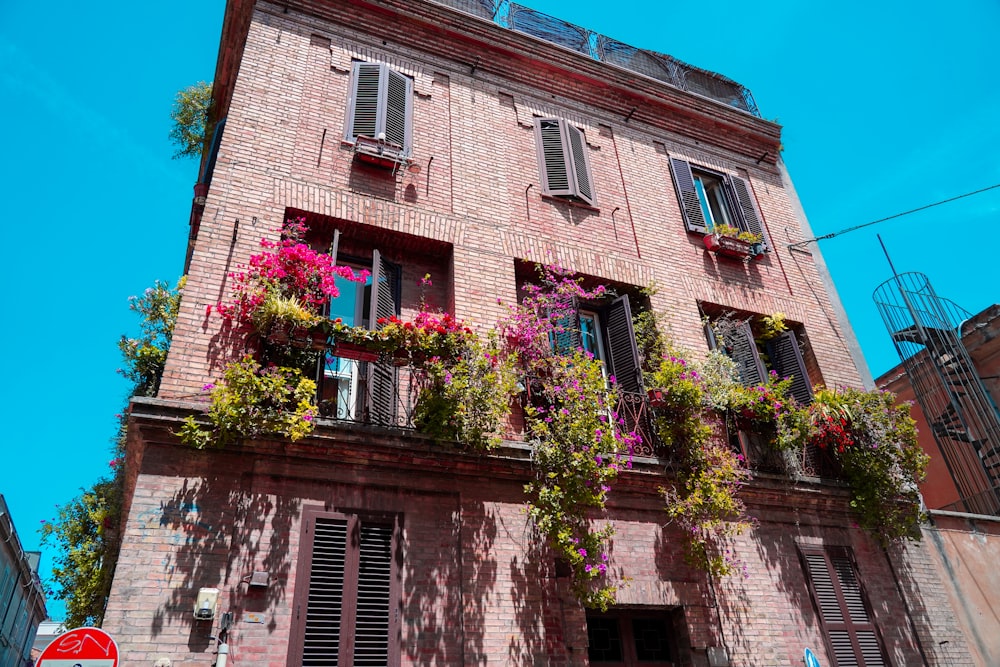 a tall brick building with lots of flowers on it