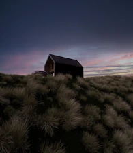 A minimalist, dark-toned cliffside villa silhouette under muted twilight.