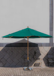 A sleek outdoor aluminum umbrella casting shade over a wooden patio table.