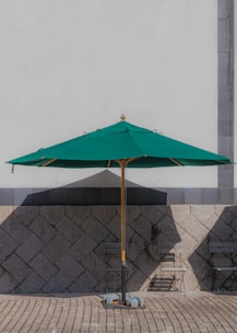 A sleek outdoor waterproof umbrella standing tall on a sunny patio, casting a cool shade.