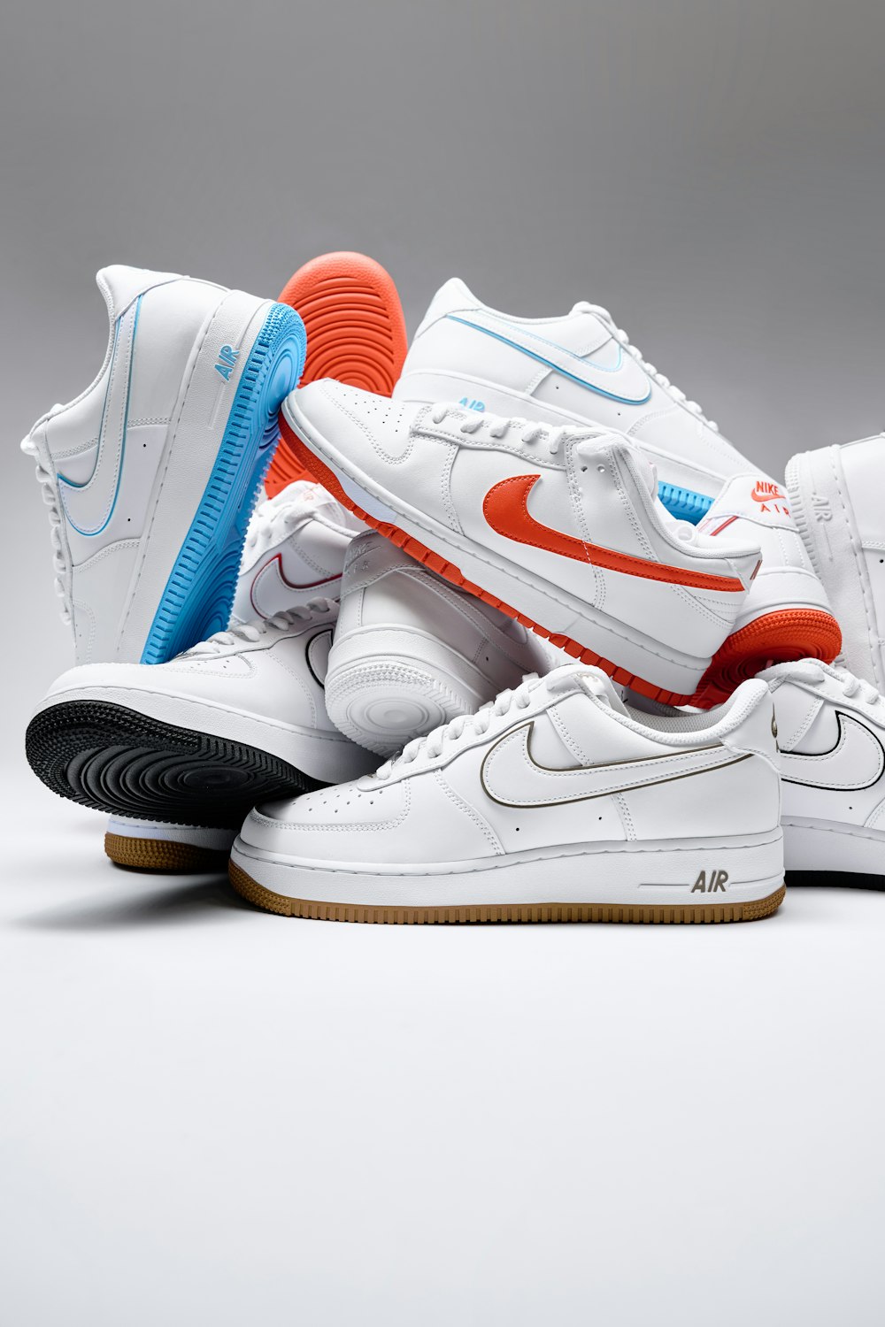 a pair of white sneakers with orange and blue accents