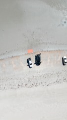 A bright sunny day showing a diverse range of vehicles parked near a sandy beach in Mayotte.