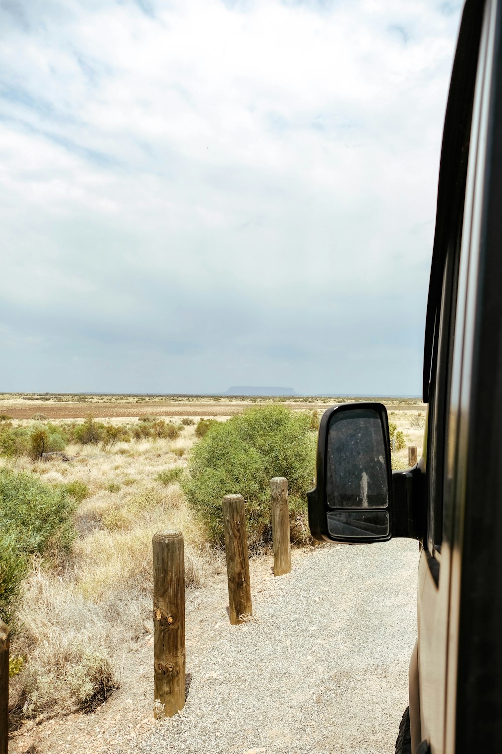 a truck is parked on the side of a dirt road