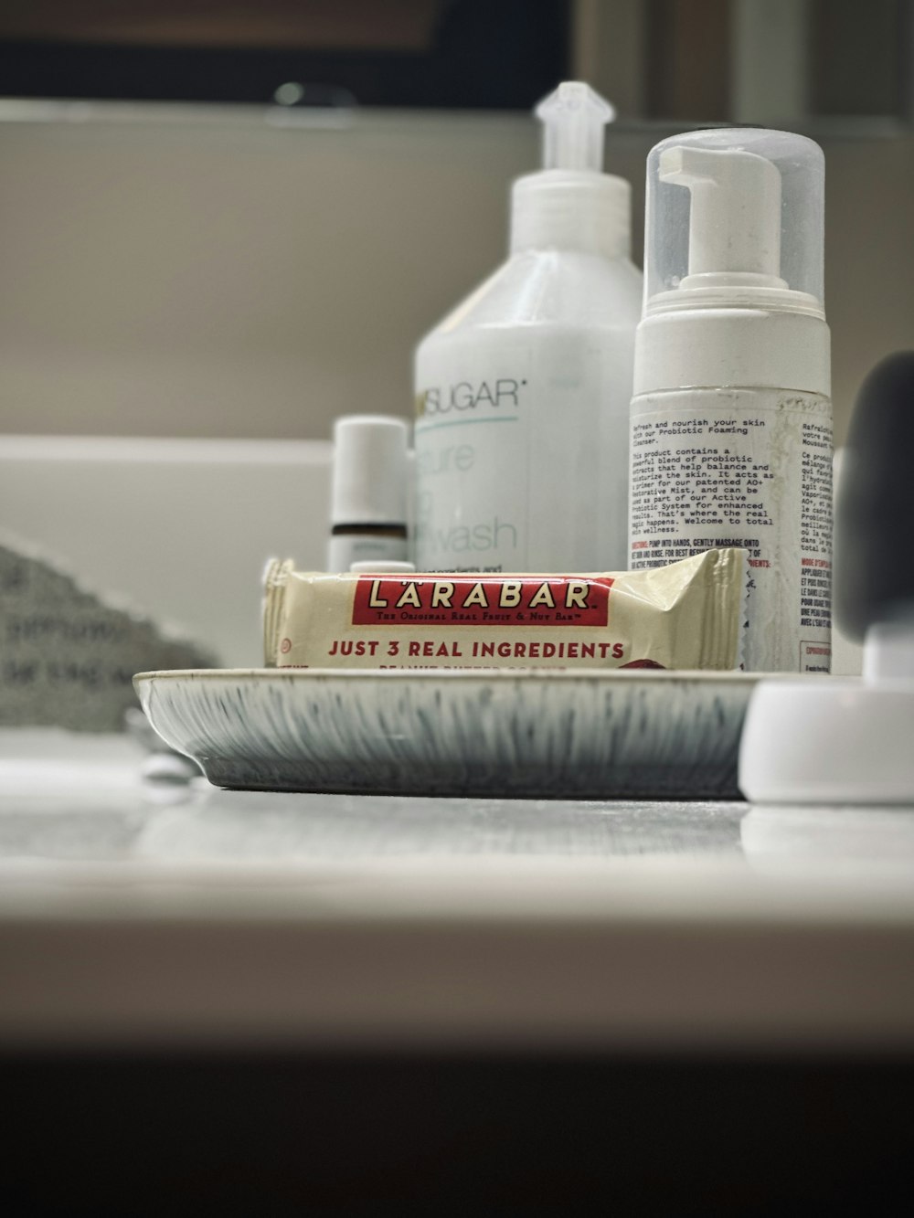 a close up of a bathroom sink with toothpaste and lotion