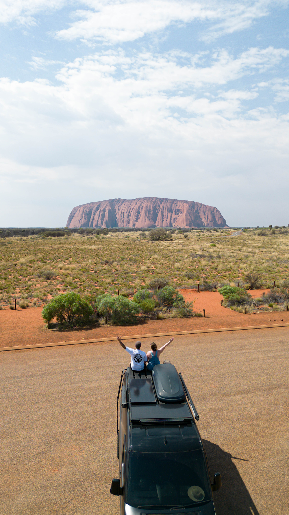 a car parked on the side of the road with a mountain in the background