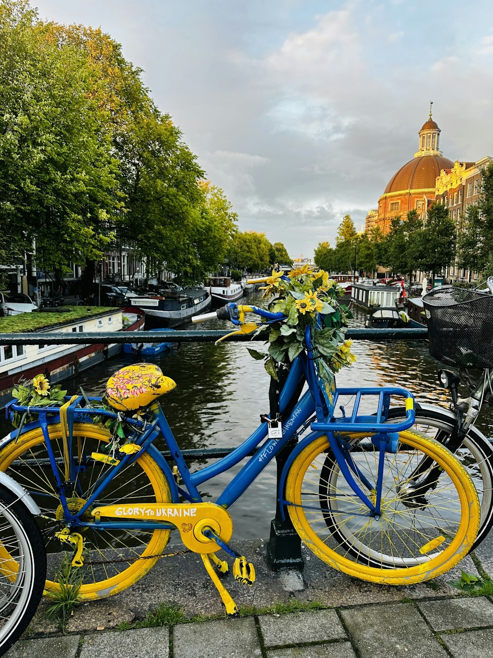 a blue and yellow bike parked next to a river