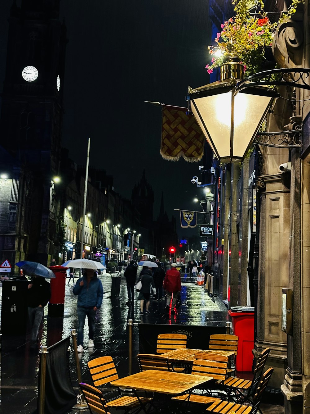 a group of people walking down a street at night