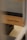A close-up view of a Pilates reformer bearing the brand name 'bonPILATES'. The equipment is made of light-colored wood with a dark padded surface.