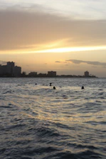 Swimmers preparing at dawn with the iconic El Arco in the background.