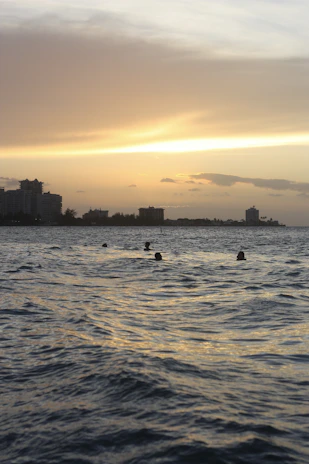 Swimmers preparing at dawn with the iconic El Arco in the background.
