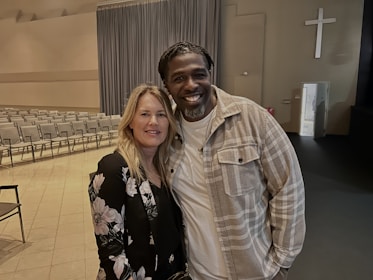Couple attending a lively marriage workshop in a cozy church hall.