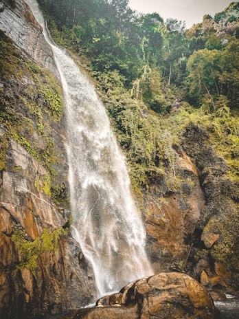 The majestic Chitrakot waterfall cascading down rocky cliffs surrounded by dense forest.