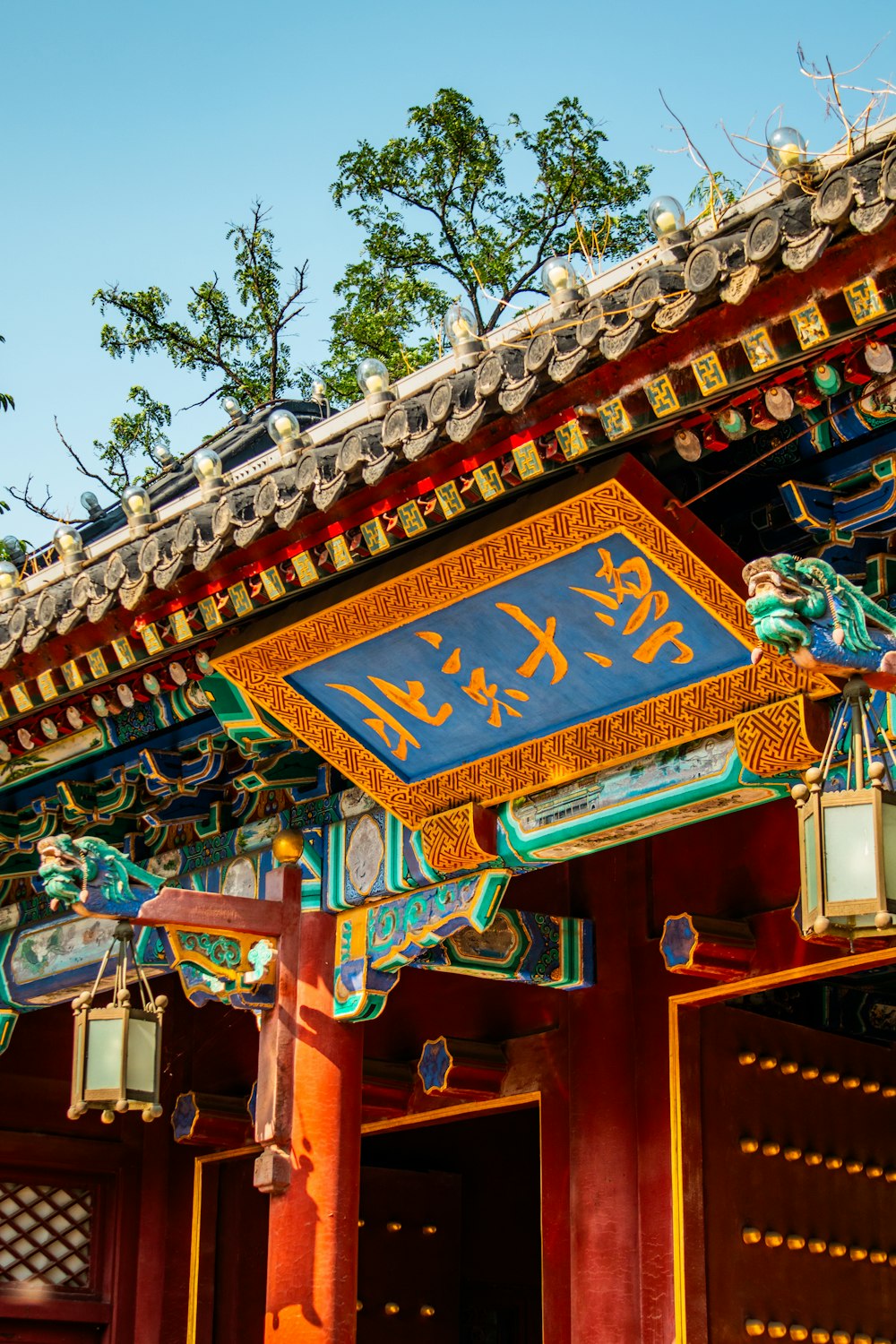 a chinese building with a blue sign hanging from it's roof