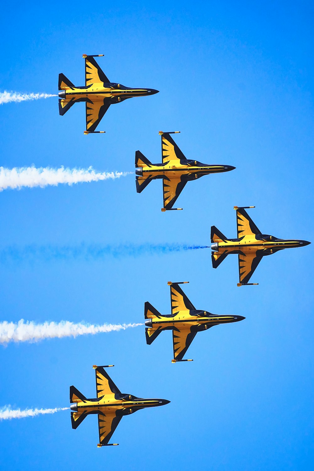 a group of fighter jets flying through a blue sky