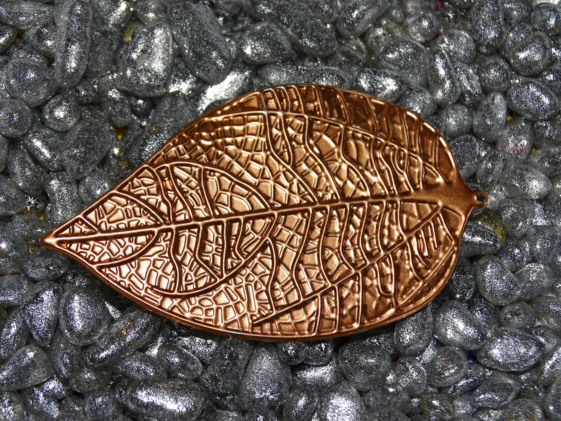 a brown leaf laying on top of a pile of rocks