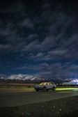 Evening view of a taxi parked near a cozy Himachal village under a starry sky.