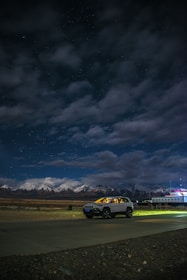 A cozy taxi parked by a scenic mountain road in Manali at sunrise.