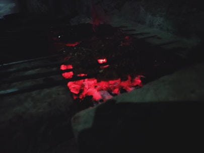 Close-up of a handcrafted smoker grill glowing warmly under soft ember lighting.