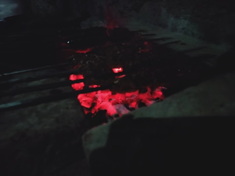 Smoked steel smoker grill glowing faintly under ember's warm light.