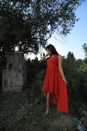 A stylish woman wearing a flowing dress in a serene outdoor setting.