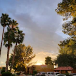 Sunset casting warm light over Bel Air, with a prominent 'For Sale' sign displaying belairre.com in the foreground.