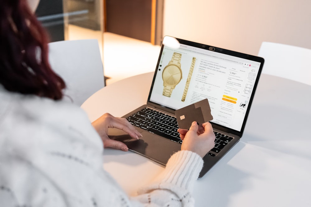 una mujer sentada en una mesa usando una computadora portátil