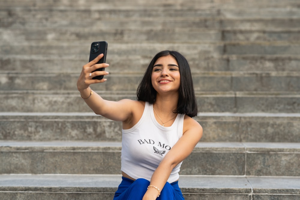 uma mulher tirando uma selfie com o celular