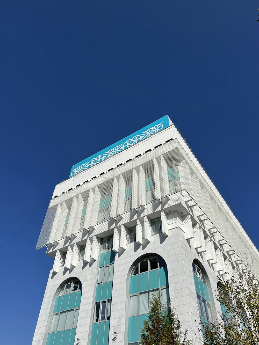 a tall white building with a blue sign on top of it
