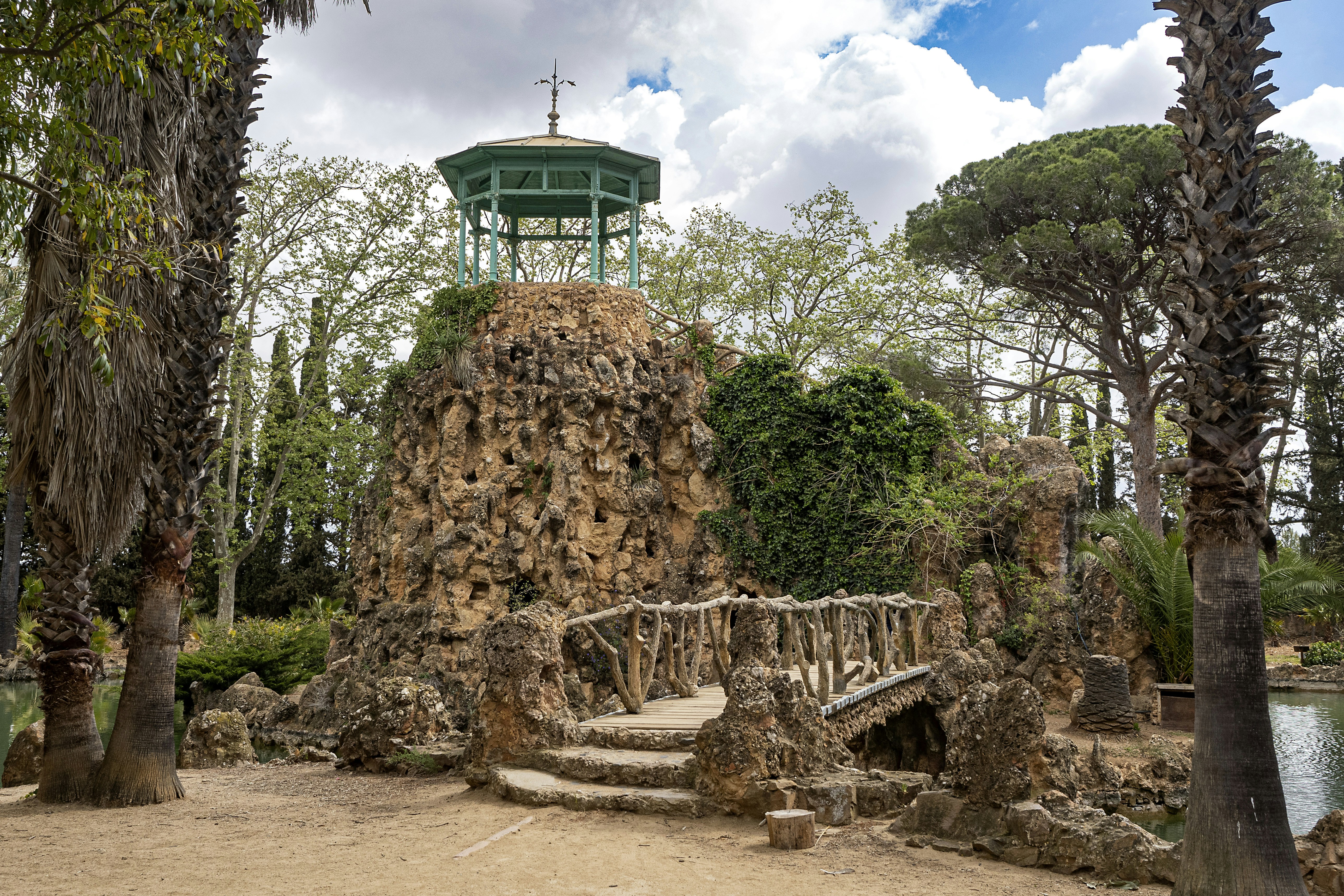 a stone bridge with a green tower in the background