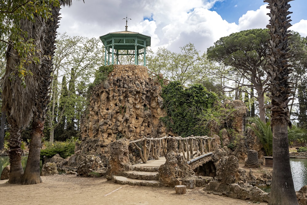 a stone bridge with a green tower in the background